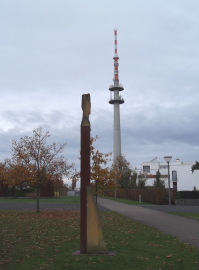 Skulptur "Wächter der Bäume" des französischen Bildhauers Guy Charlier, im Hintergrund der Fernsehturm